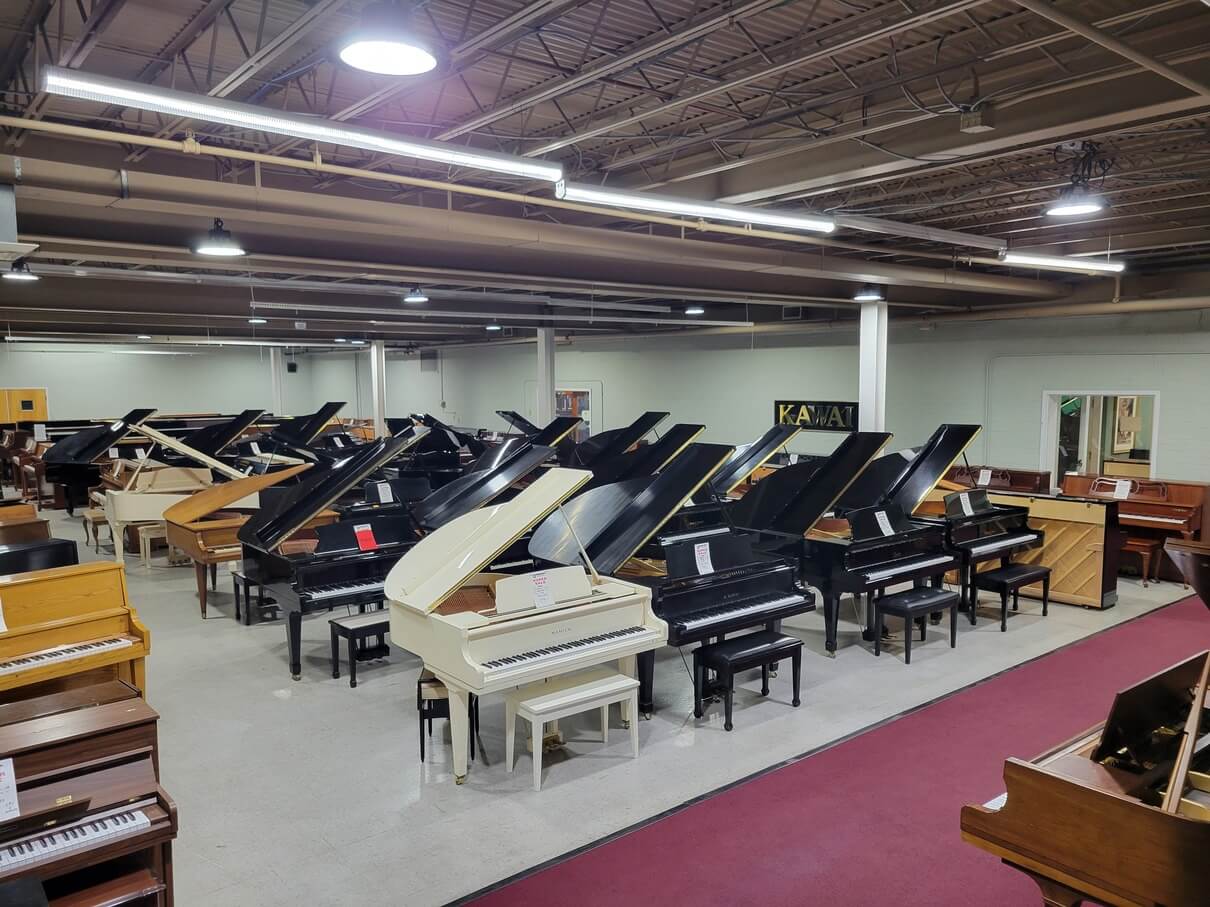 This is an overview picture of the main showroom, with many different types of piano, inside Piano Man Superstore.